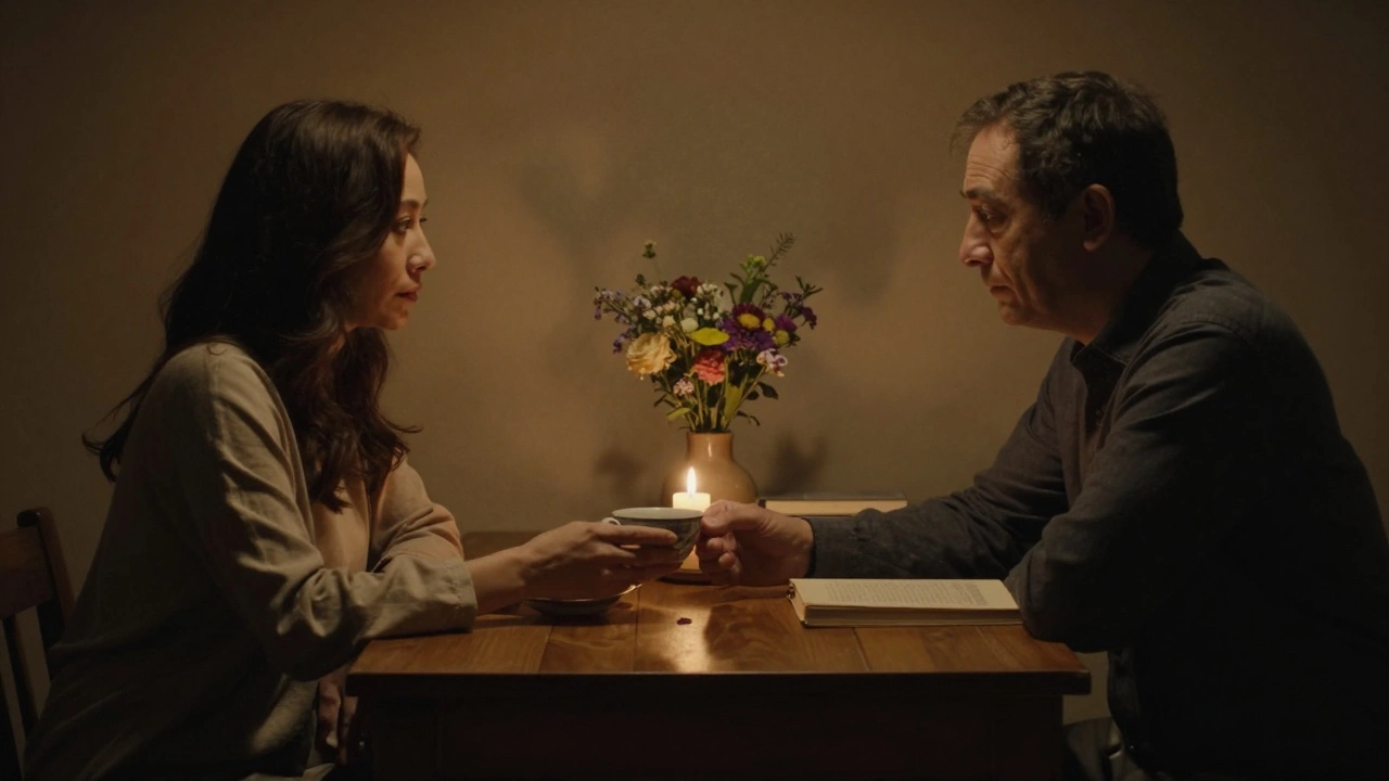 A woman offering tea to a man at a quiet table, candlelight between them in the evening.